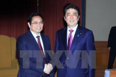 日本首相安倍晋三（右）与越日友好议员小组主席范明政。