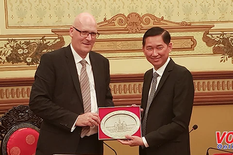 越南胡志明市人民委员会副主席陈永线（右）向丹麦气候、能源和建筑部国务秘书兼常务副部长托马斯•埃格博赠送礼物。