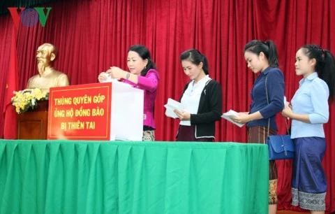 旅居老挝越南人社群为受灾群众捐款。（图片来源：越通社）