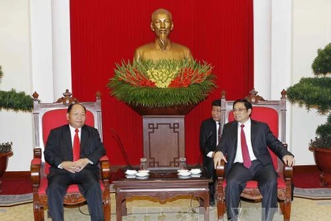 越共中央组织部部长范明正（右）会见老挝内务部部长坎曼•舒魏勒。（图片来源：越通社）