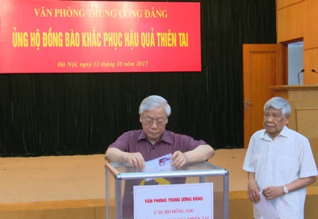 越共中央总书记阮富仲为各省水灾灾民捐款。