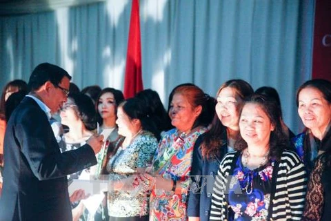 驻莫桑比克大使阮文忠向旅莫越南妇女送花(图片来源：越通社）