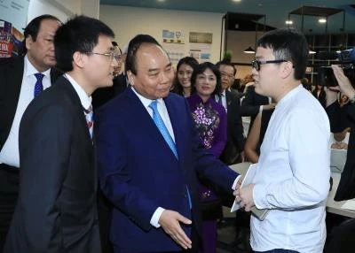越南政府总理阮春福一行走访新加坡管理大学。（图片来源：越通社）