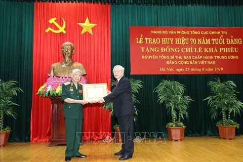 越共中央总书记、国家主席阮富仲向原越共中央总书记黎可漂授予70年党龄纪念章