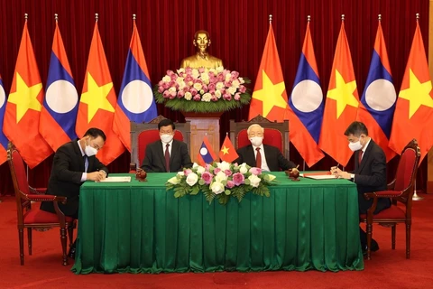 越共中央总书记阮富仲与老挝人民革命党中央总书记、国家主席通伦出席越老合作文件签字仪式