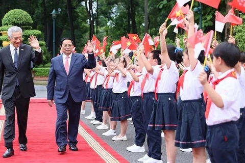 越南政府总理范明政举行仪式欢迎新加坡总理李显龙访越