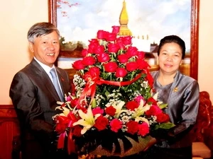 越南驻老挝大使阮孟雄向老挝人民革命党中央委员、中央对外部副部长、老挝外交部副部长Sounthon Saynhachac女士致以越南大使馆对老挝人民革命党建党58周年的祝福