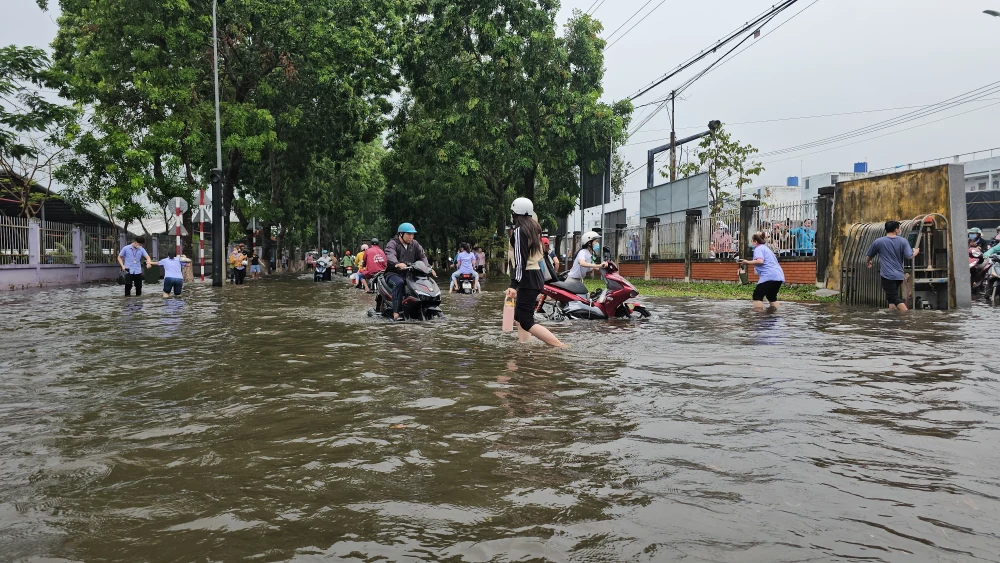 Workers wade through floodwater at the Giao Long Industrial Park in Chau Thanh district, Ben Tre province, due to heavy rains during May 20 night and early May 21. (Photo: VNA)