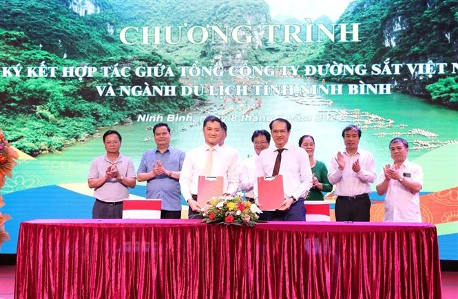 Representatives of the Ninh Binh Tourism Department and the Vietnam Railway Corporation show the signed MoU on cooperation. (Photo: VNA)