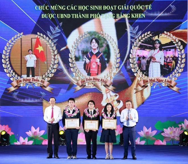 Deputy Minister of Education and Training Pham Ngoc Thuong (first, left) and Chairman of the Hanoi People’s Committee Tran Sy Thanh (first, right) present rewards to outstanding students at the conference on August 14. (Photo: VNA)