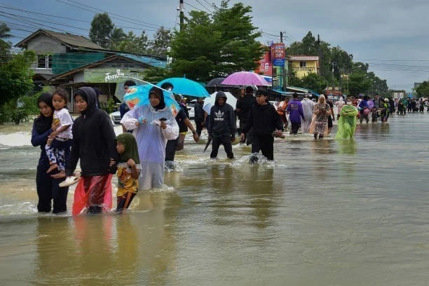 People wade through flood water in Narathiwat province of Thailand. (Photo: Getty Images/VNA)