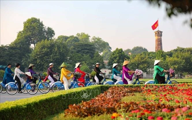 "Ao dai" wearers cycle near the Flag Tower of Hanoi. Vietnam sees the biggest improvements in diplomatic influence and cultural influence in the Asia Power Index 2024 rankings. (Photo: VNA)