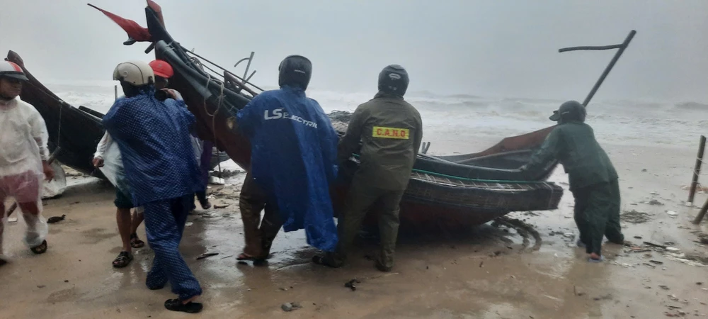 Authorities assist fishermen to move boats onto the shore before Storm Trami hit the mainland in Thua Thien - Hue province. (Photo: VNA)