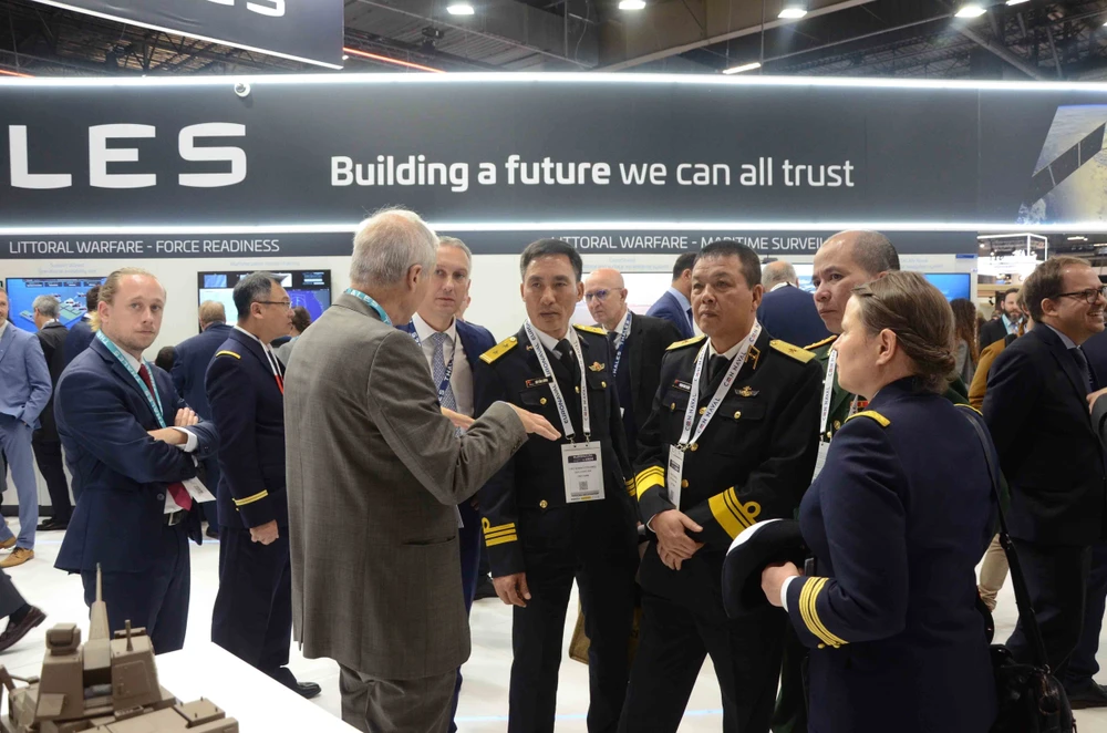 Members of the Vietnamese delegation listen to an expert from the Thales group introducing new naval weapons and technologies at Euronaval 2024. (Photo: VNA)