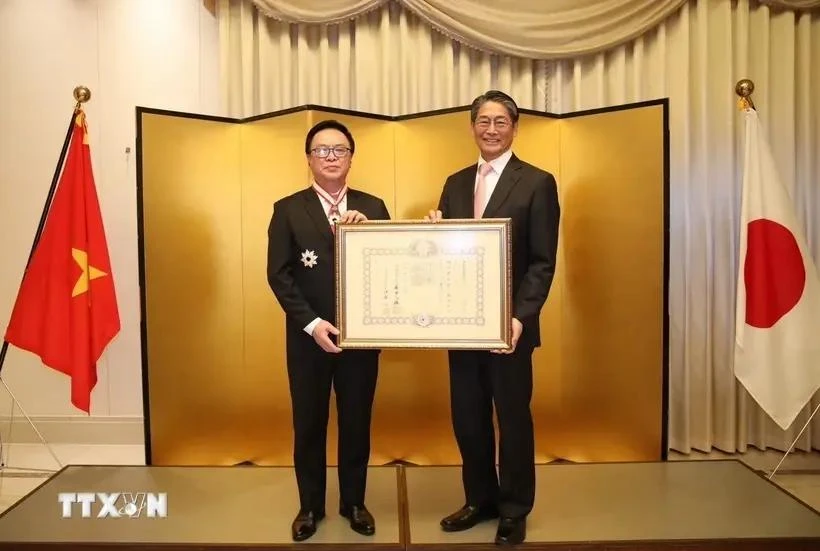 Hoang Binh Quan (left), former member of the Party Central Committee and former Chairman of its Commission for External Relations, receives the “Order of the Rising Sun, Gold and Silver Star” from Japanese Ambassador Ito Naoki on December 15. (Source: VNA)