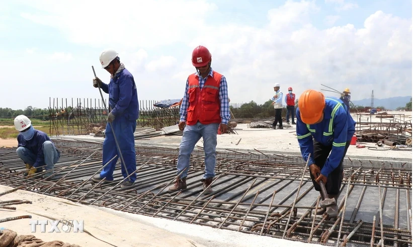 Des travailleurs sur le chantier de construction du pont de Da Rang dans le cadre du projet de l'autoroute Nord-Sud. Photo : VNA