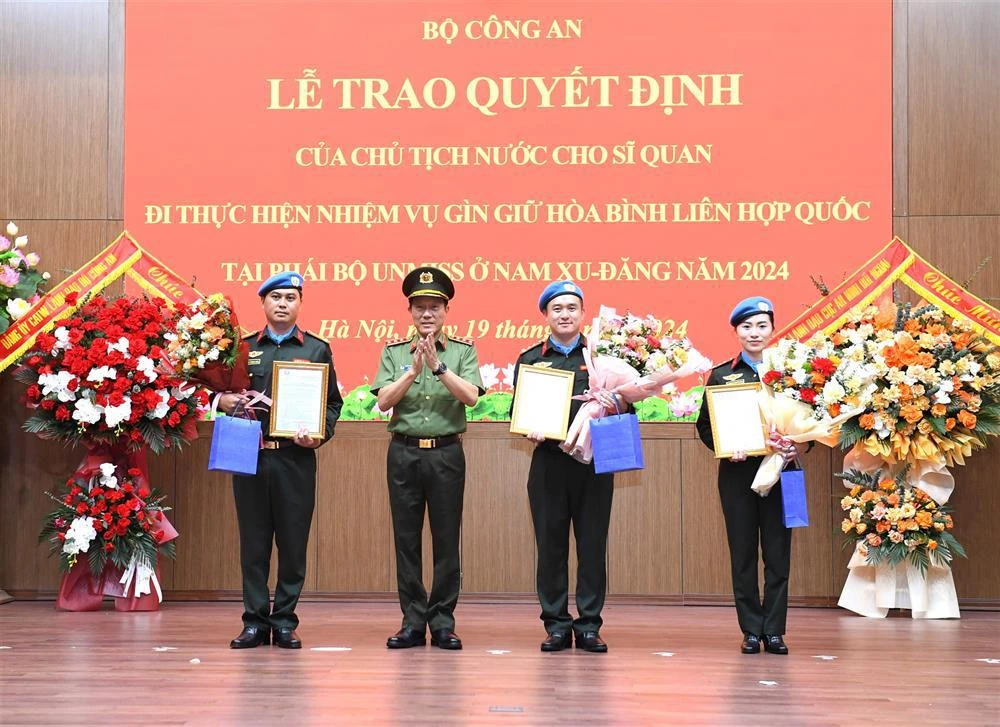 Le ministre de la Sécurité Publique, Luong Tam Quang, remet la décision du président à trois officiers. Photo: bocongan.gov.vn