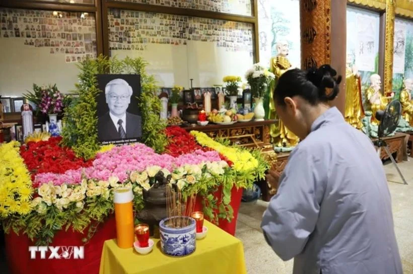 Une Vietnamien à l'étranger offre de l'encens au défunt secrétaire général du Parti Nguyen Phu Trong. Photo : VNA