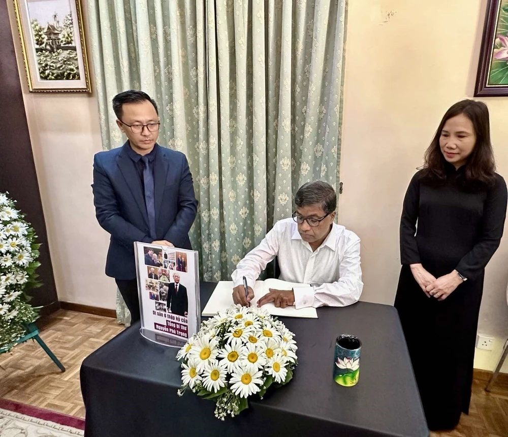 Le secrétaire général du Parti communiste du Sri Lanka G.Weerasinghe écrit dans le registre de condoléances à la mémoire du secrétaire général Nguyen Phu Trong. Photo: VNA