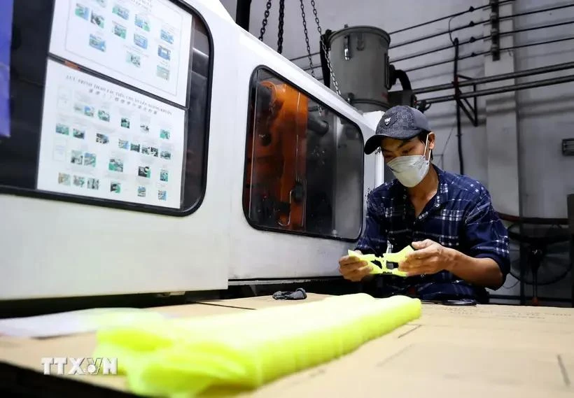 Un ouvrier fabrique des moules en plastique pour produire des chaussures en cuir dans une usine située à la ville de Thuan An, province de Binh Duong. Photo: VNA