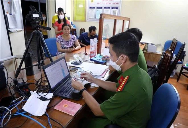 La police de la commune de Yen Thuong, district de Gia Lam, à Hanoï, aide les habitants à effectuer les procédures d'enregistrement de la carte d'identité à puce. Photo: VNA