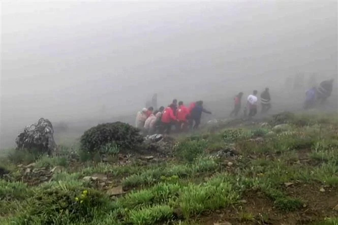 Los rescatistas trasladan cuerpos de las víctimas al lugar del accidente aéreo. (Fuente:AFP/VNA)