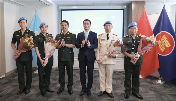 El embajador Dang Hoang Giang, jefe de la misión permanente de Vietnam ante la ONU, entre flores a oficiales connacionales participantes en las actividades del mantenimiento de la paz de las Naciones Unidas. (Fuente:VNA)