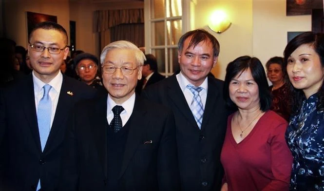 Vu Kim Thanh (medio) y su esposa se tomaron una fotografía de recuerdo con el Secretario General Nguyen Phu Trong durante su visita al Reino Unido en 2013. (Fuente: VNA)