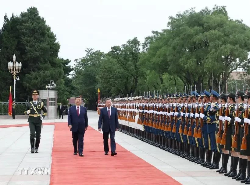 El secretario general del Partido Comunista de Vietnam y presidente del país, To Lam (derecha), y el secretario general del Partido Comunista y presidente de China, Xi Jinping, en el acto de bienvenida. (Foto: VNA)