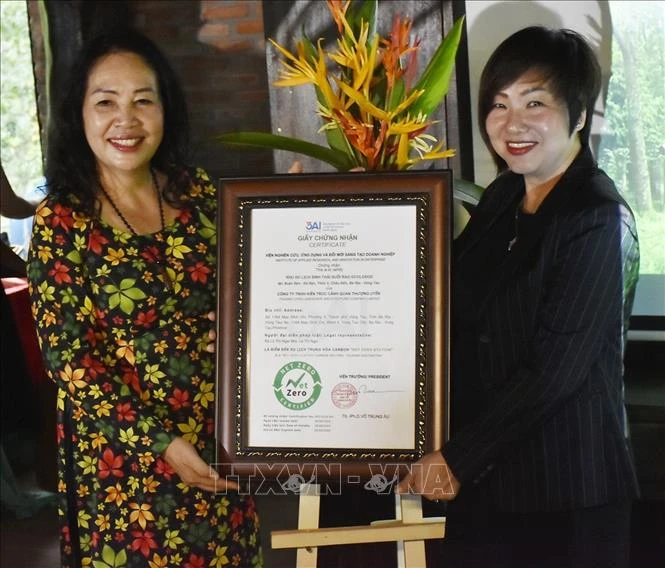 Ngô Kim Trang, subjefa del Instituto de Investigación Aplicada e Innovación en Empresas, entrega el certificado de estación de cero emisiones netas al complejo Suoi Rao Ecolodge. (Fuente:VNA)