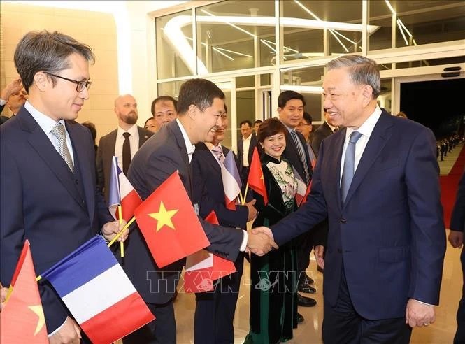 Funcionarios y empleados de la Embajada y la comunidad de residentes vietnamitas en Francia reciben al secretario general del Partido Comunista de Vietnam y presidente del pa'is, To Lam, en el aeropuerto de Orly en París. (Fuente:VNA)