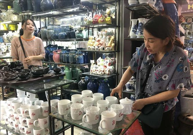 Clientes compran productos en el mercado de cerámica de Bat Trang, en Hanoi. (Fuente: VNA)