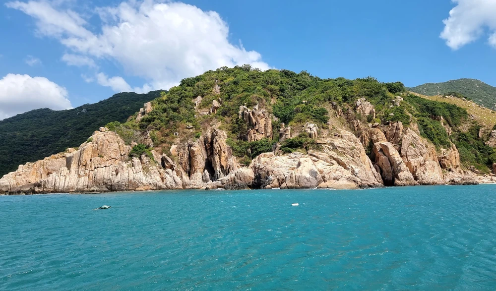 Paisaje lírico en la bahía de Vinh Hy con extensos bosques montañosos y mar azul (Fuente: VNA)