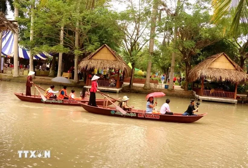 Los turistas experimentan remar en el río en la aldea turística My Khanh, en la ciudad de Can Tho. (Fuente: VNA)