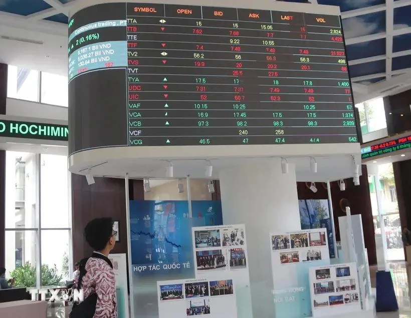 Los inversores monitorean las listas de precios de las acciones en la bolsa de valores de Ciudad Ho Chi Minh- HOSE (Fuente: VNA)