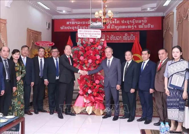 El subsecretario permanente del Comité del Partido de Ciudad Ho Chi Minh, Nguyen Ho Hai, (en el centro a la izquierda), entrega flores para felicitar al cónsul general adjunto de Laos, Amphay Souvannasen. (Fuente: VNA)