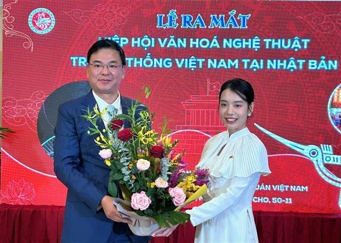 El embajador de Vietnam en Japón, Pham Quang Hieu, entrega un ramo de flores a la presidenta de la asociación de cultura y arte tradicional vietnamita en Japón, Do Khanh Han. (Foto: VNA)