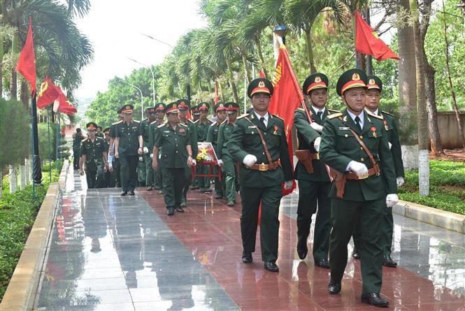 为在柬埔寨牺牲的烈士遗骸举行追悼会及安葬仪式。图自越通社