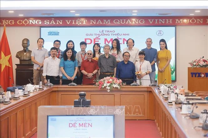 Le poète Tran Dang Khoa et le rédacteur en chef du journal Sports et Culture Le Xuan Thanh décernent le prix "Chevalier de Grillon" au représentant de l'auteur Ly Lan. Photo: VNA
