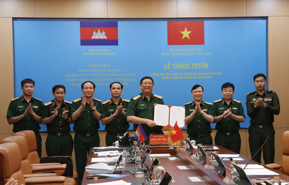 Le général de corps d'armée Huynh Chien Thang, chef adjoint de l'état-major général de l'Armée populaire du Vietnam signe un document sur l'ouverture d'une ligne téléphonique directe entre l'État-major général de l'Armée populaire du Vietnam et le commandement général des forces armées royales du Cambodge. Photo: VNA