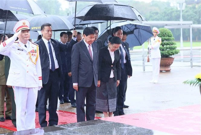 Le secrétaire général du Parti populaire révolutionnaire lao et président du Laos Thongloun Sisoulith et son épouse, accompagnés d'une délégation de haut rang du Parti et de l'État du Laos, rend hommage au Président Hô Chi Minh en son mausolée. Photo: VNA