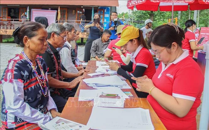 Le comité d'organisation aide des habitants de l'ethnie Co Tu à enregistrer des cartes SIM. Photo: VNA