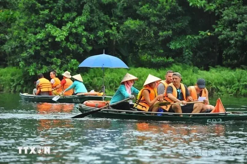 Des touristes nationaux et étrangers visitent la zone touristique de Trang An (Ninh Binh). Photo: VNA