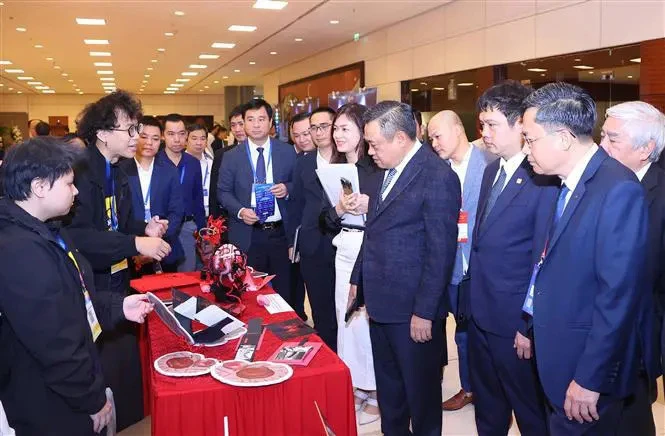 Le président du Comité populaire de Hanoï, Tran Sy Thanh, et d'autres délégués visitent la zone d'exposition des produits et services au service de la construction de villes intelligentes. Photo: VNA