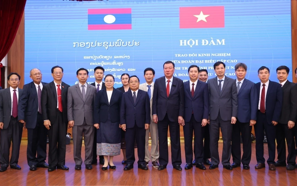 L'inspecteur général du gouvernement vietnamien Doan Hong Phong et son homologue lao Khamphan Phommaphat prennent une photo avec les inspecteurs de deux pays. Photo: VNA