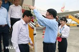 Le Khac Nam, vice-président du Comité populaire de la ville de Hai Phong, offre des fleurs aux passagers du vol. Photo: VNA