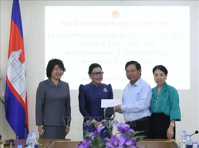 Chea Sam Eng, représentante des Cambodgiens qui ont étudié au Vietnam au début des années 1980 remis un don pour soutenir les les victimes des récentes catastrophes naturelles au Vietnam. Photo : VNA