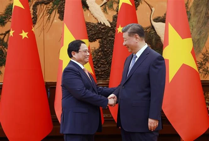 El primer ministro de Vietnam, Pham Minh Chinh, y el secretario general del Partido Comunista y el presidente de China, Xi Jinping. (Foto: VNA)