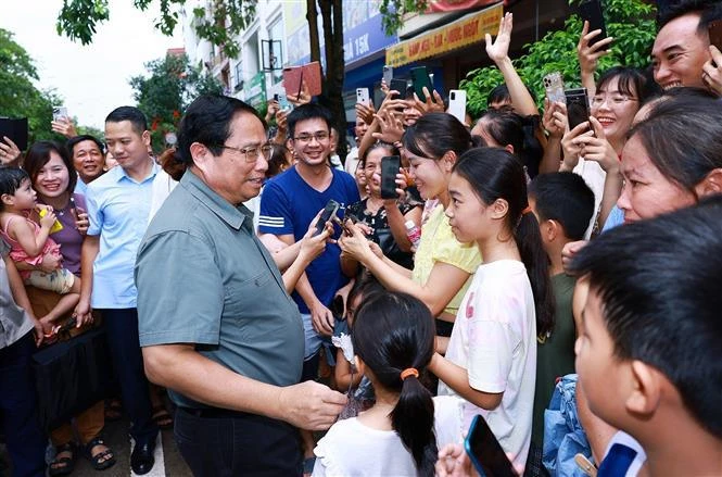 El primer ministro Pham Minh Chinh con los residentes del proyecto de vivienda social Thong Nhat. (Foto: VNA)