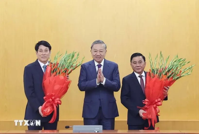 El secretario general del Partido Comunista de Vietnam, To Lam, entrega flores al miembro del Buró Político y presidente. Luong Cuong. y el miembro del Buró Político y permanente del Secretariado del Comité Central del Partido. (Foto: VNA)